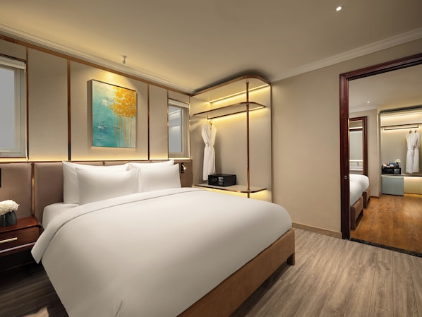 Une chambre d’hôtel moderne avec un grand lit, une table de chevet, un miroir et une armoire.