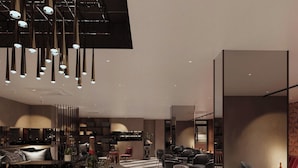 A modern interior with a bar area, seating, and a kitchen in the background. - Splendid Secret Hotel (Hanoi)