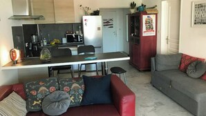 A compact living space with a kitchenette, a dining area, and a seating area with a sofa and a couch. - Whole apartment in Six-Fours-les-Plages, France (Six-Fours-les-Plages)