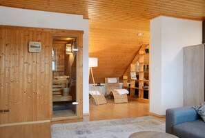 A wooden interior with a loft bedroom, a sofa, and a wicker chair. - Apartment 'Karin' with Wi-Fi (Spalt)