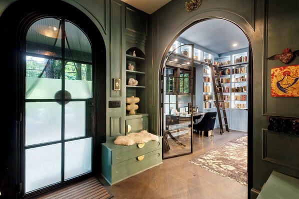 A library with bookshelves, a ladder, and a desk.