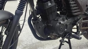 Une moto dont le moteur et le guidon sont bien visibles, garée dans un environnement urbain.