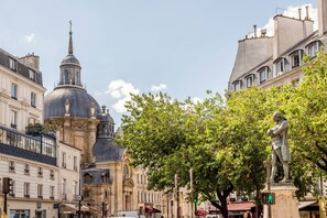 A street scene with historic buildings, a prominent dome, and a statue. - Merveil Luxury Suites - Marais - Antoine I-II (Paris)