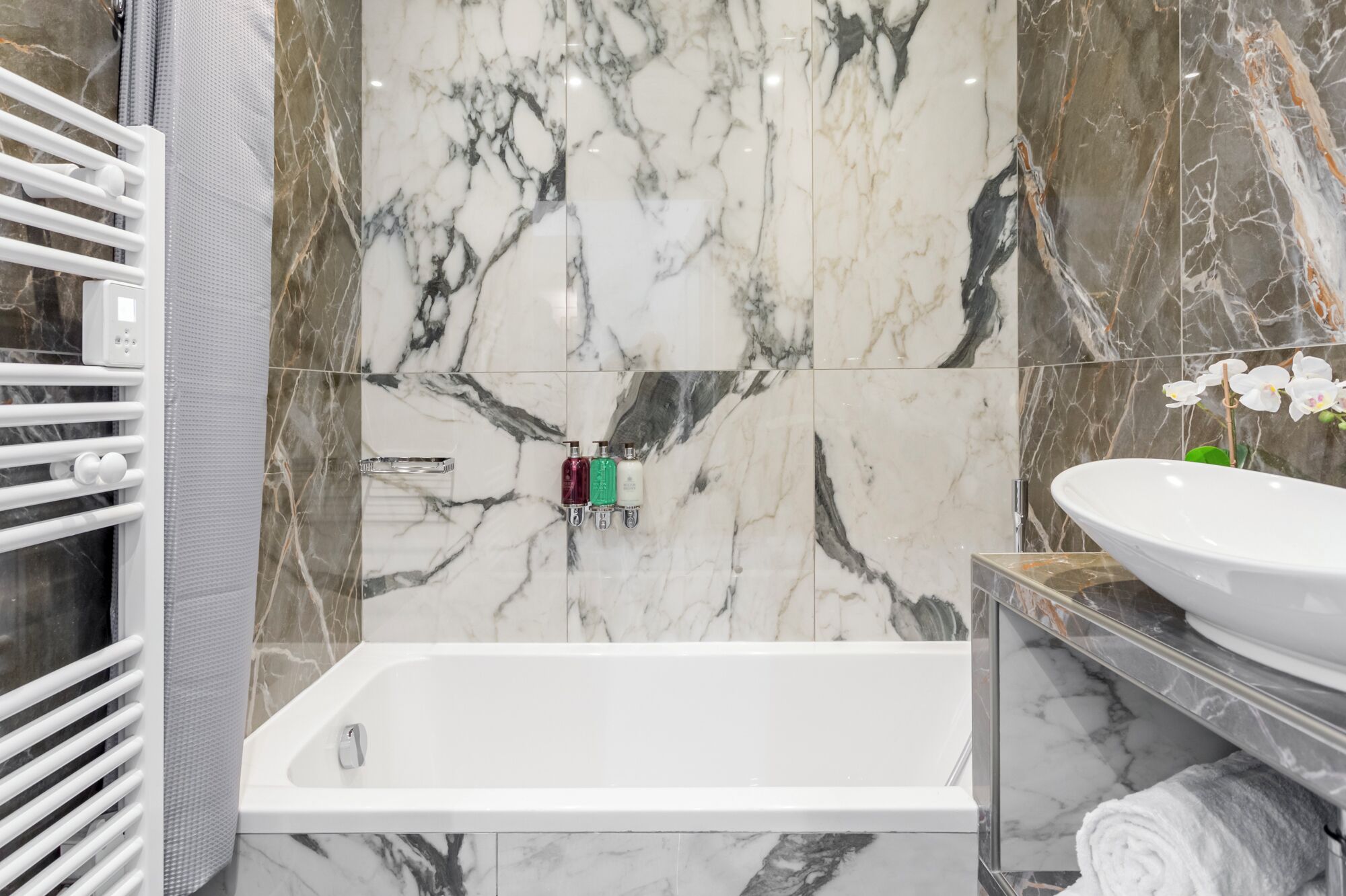 Ein modernes Badezimmer mit einer weißen Badewanne, einem Waschbecken und einer Duschkabine.