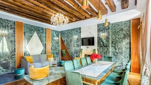 A modern dining area with a marble wall, wooden ceiling, and a chandelier. - Merveil Luxury Suites - Marais - Antoine I-II (Paris)
