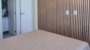 Un dormitorio con una cama grande, un cabecero de listones de madera y un ventilador de techo.