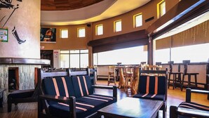 A restaurant with a curved ceiling, wooden flooring, and striped upholstered seating. - Sanel Hotel and Lounge Naivasha (Naivasha)