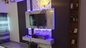 A modern dining area with a marble countertop, a television mounted on a wall, and a decorative shelf with items. - Furnished studio, Douala-Total Nkolbong close to the road and all amenities (Douala)