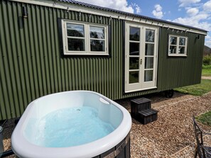 A small, single-story building with a hot tub in front. - Primrose (Grimsby)