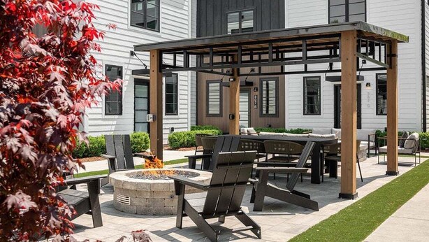 Une terrasse extérieure dotée d’une pergola, de sièges et d’un foyer.