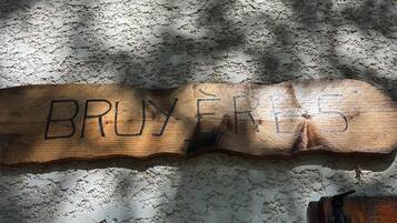 Une planche de bois sur laquelle est inscrit le mot « BRUYER », le tout posé sur un sol texturé.