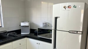 A kitchen with white cabinets, a stainless steel refrigerator, a coffee maker, and a microwave. - Center of Brasilia 5 minutes from the Esplanade of Ministries (Brasília)