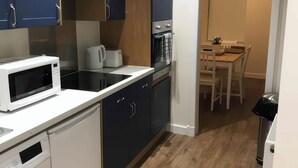 A compact kitchen with a microwave, kettle, toaster, and oven. - 2 Lower Kessock Street (Inverness)