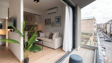 A modern apartment with a living room, kitchen, and balcony.
