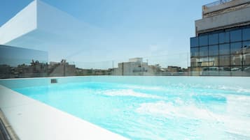 Una piscina al aire libre de temporada, sombrillas