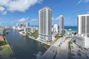 A high-rise hotel with a view of the ocean, a marina, and a bridge.