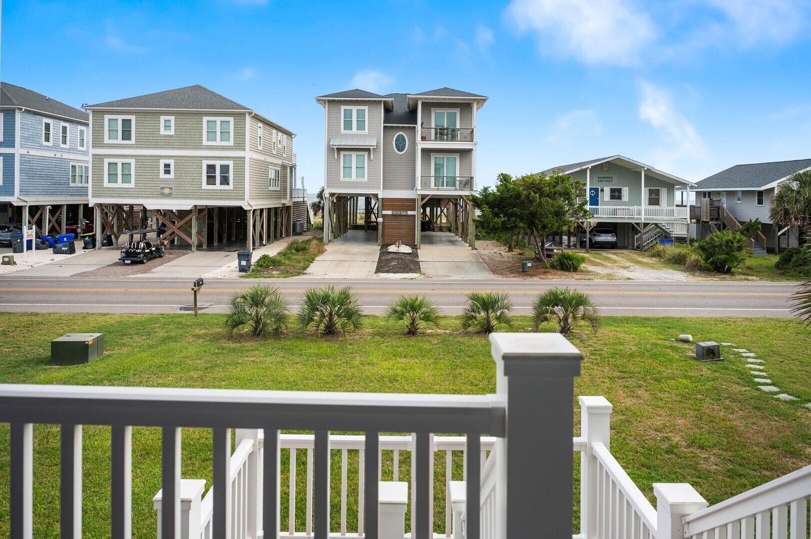 A residential area with a two-story house in the center, featuring a front porch and a garage.