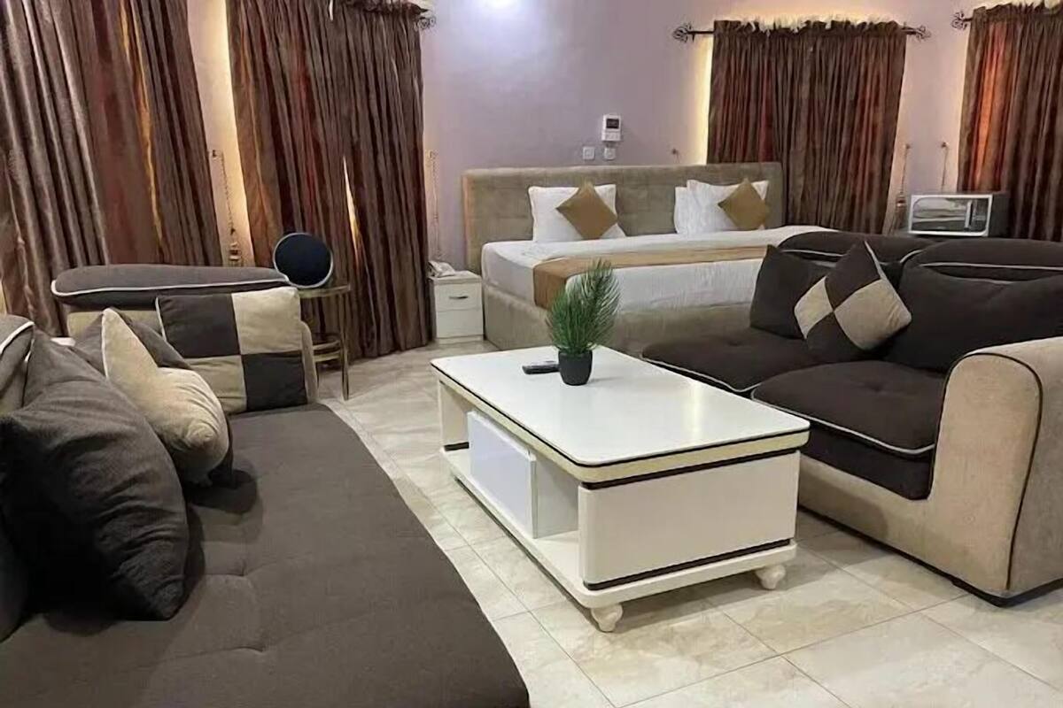 A modern living room with a sofa, a coffee table, a TV, and curtains.