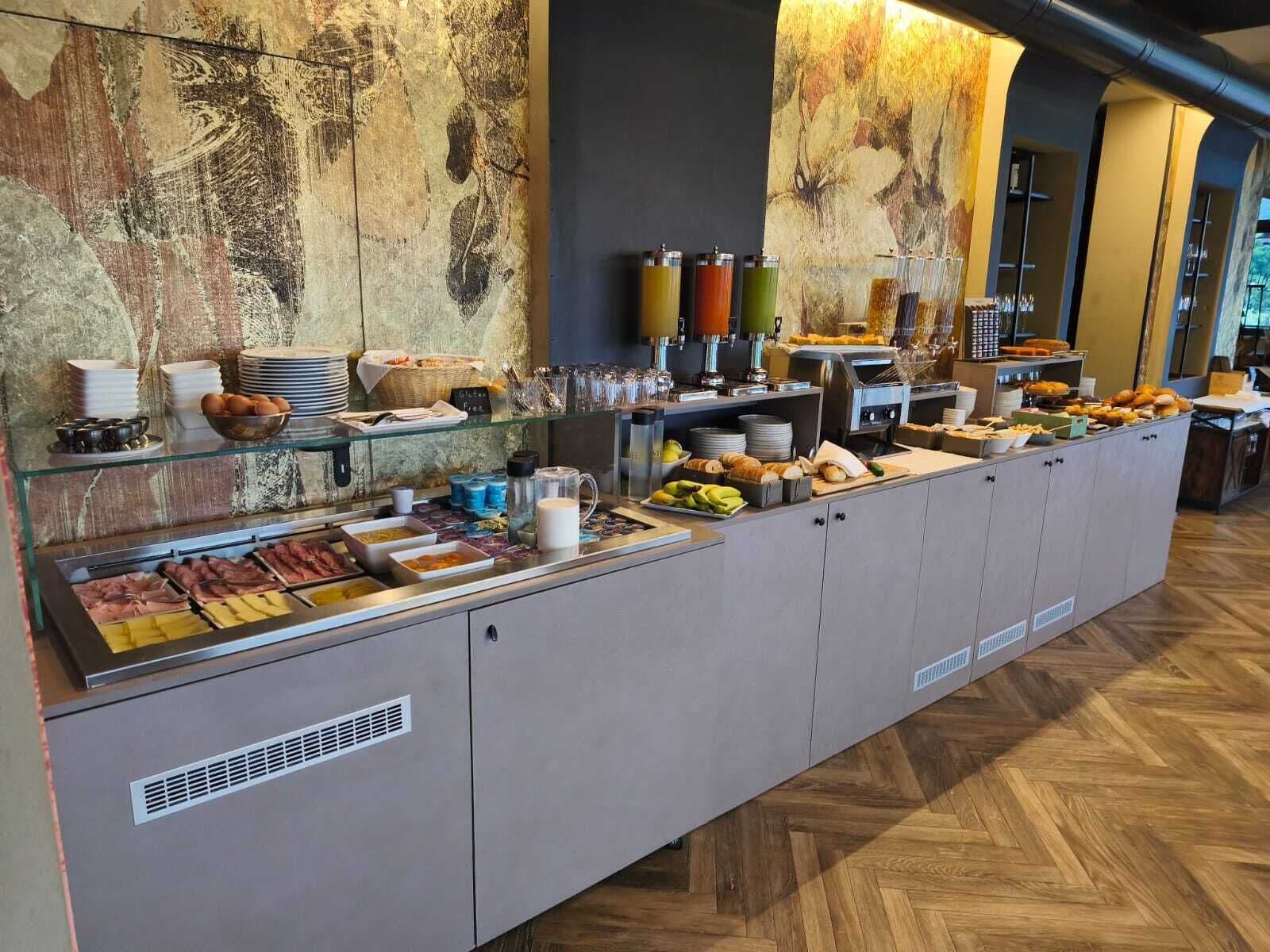 Un bufé con diversas opciones de comida y bebidas, incluyendo una sección con alternativas sin gluten.