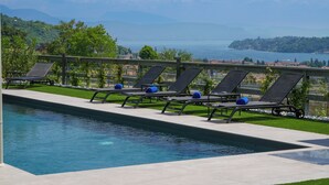 A pool with lounge chairs and a view of a lake and mountains. - Hotel Vita (Salò)
