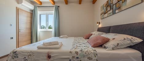 Une chambre à coucher avec un lit, une fenêtre, une porte et un luminaire fixé au mur.