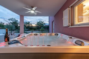 A hot tub with a ceiling fan, a bottle of wine, and glasses on a table. - Villa Rosea Domus Zadarvillas (Benkovac)