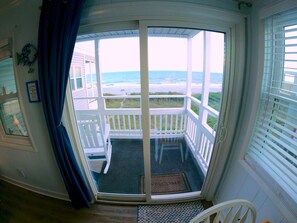 Une chambre avec vue sur la plage, une porte donnant sur l’extérieur et un petit espace porche.