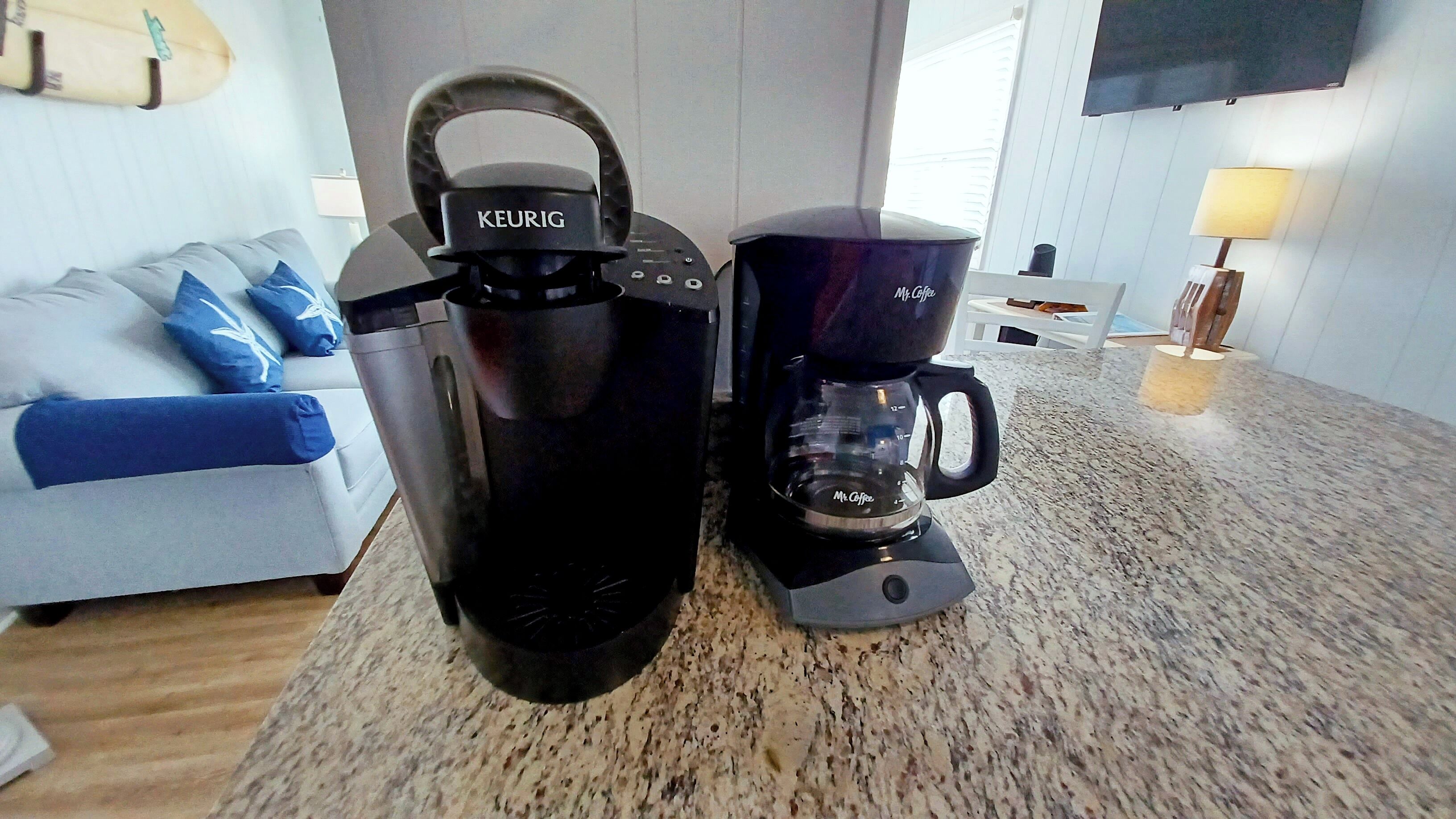 Una cafetera i un recipient d'aigua sobre una cuina.