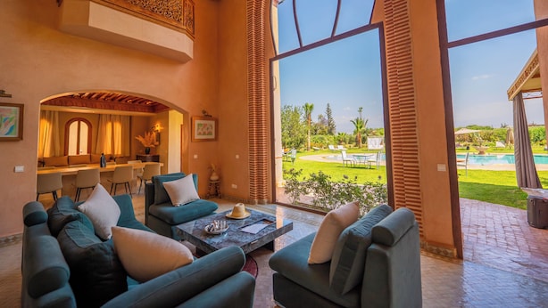 A spacious living area with a view of a pool and garden. - Villa Dar Minzah (Aghouatim)