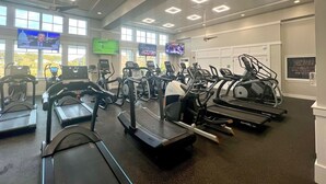 A gym with multiple treadmills, stationary bikes, and a television displaying sports events. - Deux Soeurs (Two Sisters) by Sandpiper | Near Beach (Seabrook Island)