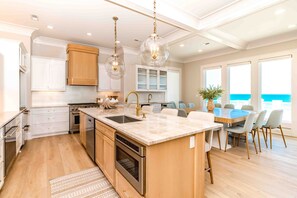 A modern kitchen with a central island, stainless steel appliances, and pendant lighting. - Ziggy's Place - New Luxury 8 BR Oceanfront Home; Pool & Elevator! (Surf City)