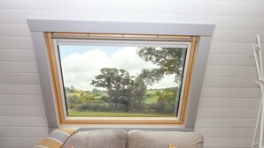 A room with a view of a green landscape through a skylight. - Under Oak Pod (Totnes)