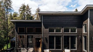A modern two-story house with a deck, large windows, and a fireplace. - Summer Getaway | Hot Tub, Kayaking & Mountain Biking (Saint-Côme)