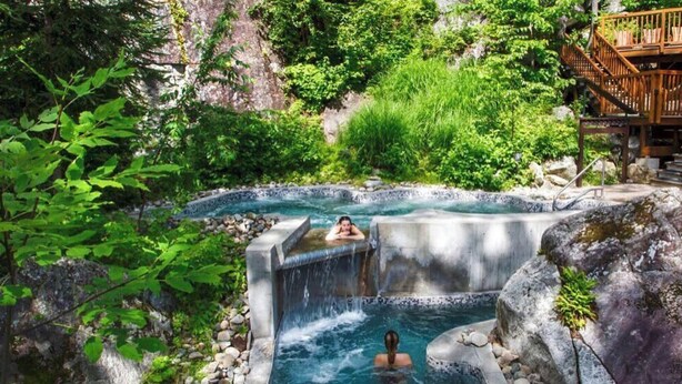 A hot spring area with a wooden deck and a waterfall. - Summer Getaway | Hot Tub, Kayaking & Mountain Biking (Saint-Côme)