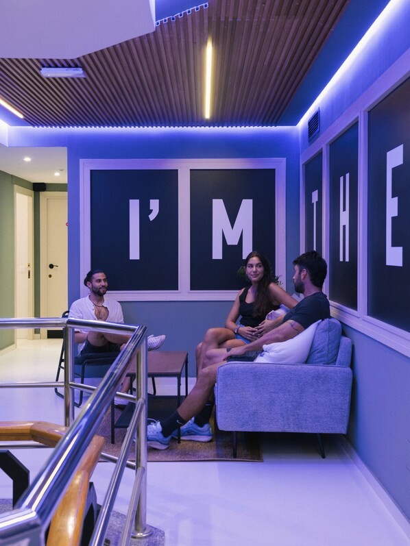 A modern lounge area with a seating arrangement and a large wall with the text "I'M THE". - U-nit Central Park (València)