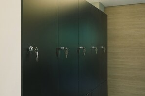 A set of dark green lockers with keys hanging on the handles. - U-nit Central Park (València)