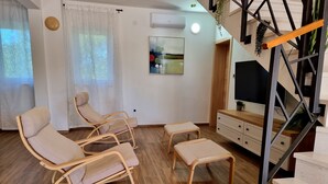 A modern living room with a wooden floor, a sofa, a coffee table, and a TV. - Villa Rosea Domus Zadarvillas (Benkovac)