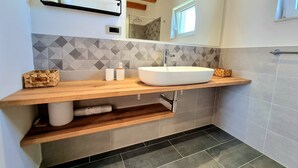A modern bathroom with a large white sink, wooden countertop, and a geometric tile backsplash. - Villa Rosea Domus Zadarvillas (Benkovac)