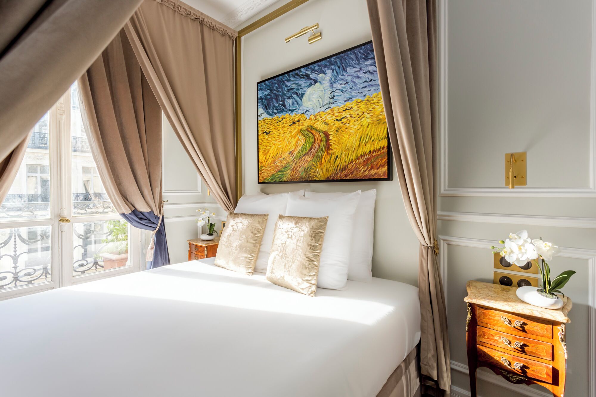 A bedroom with a bed, a nightstand, a painting, and a window with curtains.