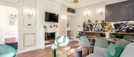 A modern living room with a fireplace, a television, and a dining area with a marble countertop.