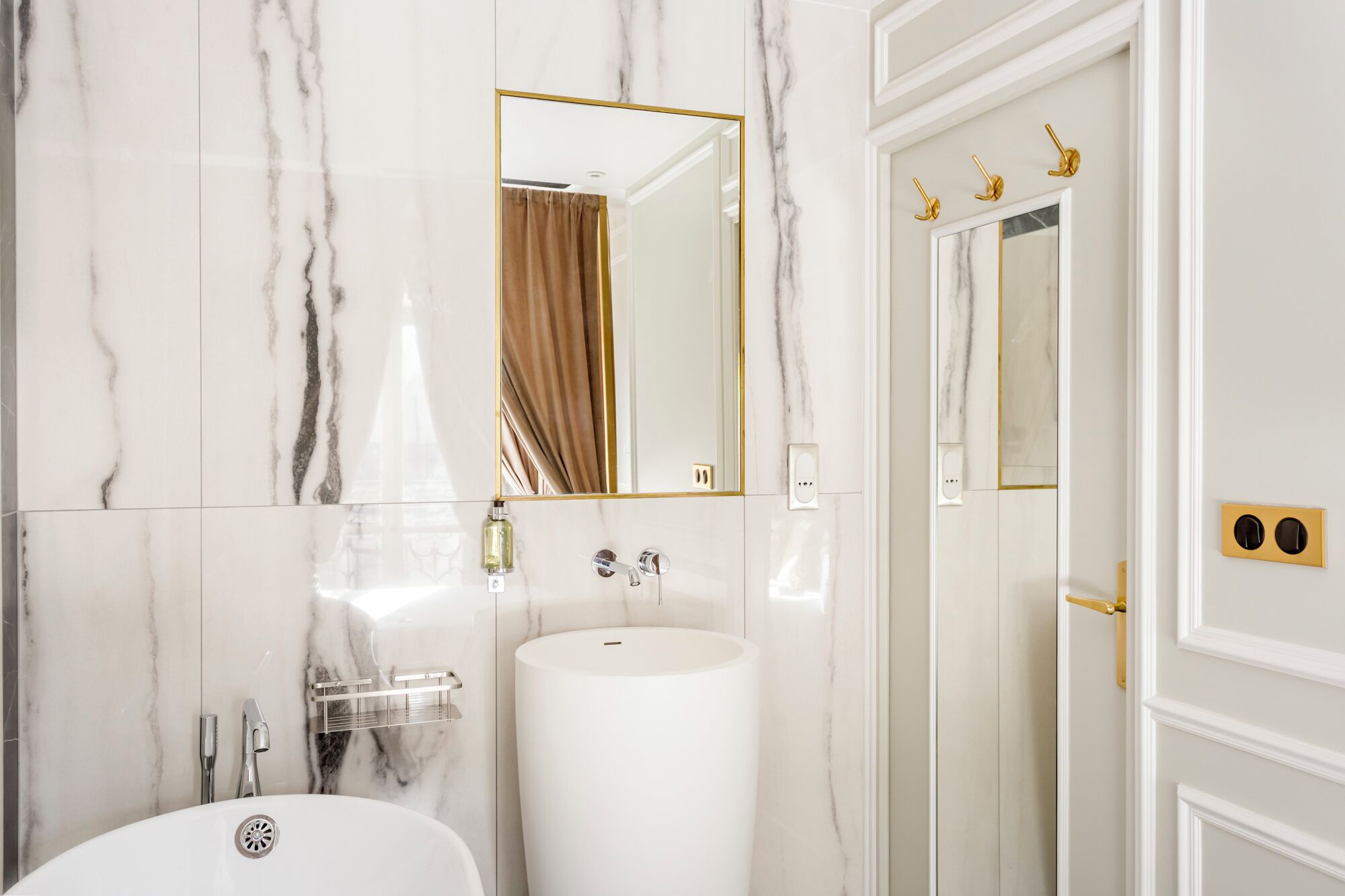 A bathroom with a white sink, a mirror, and a shower.