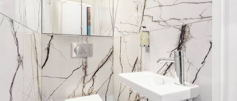 A bathroom with a white toilet, a sink, and a mirror.