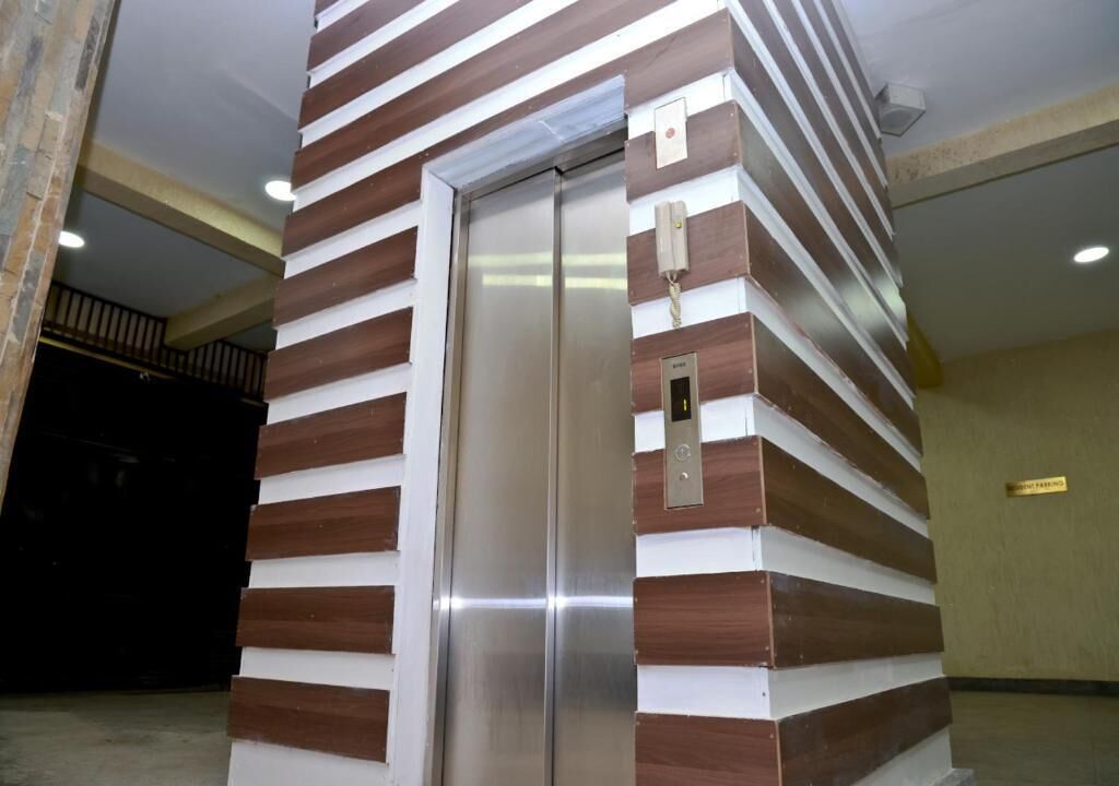 An elevator with a modern design, featuring a metallic finish and a striped pattern on the walls.