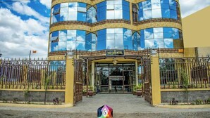 A hotel with a curved facade, large glass windows, and a gated entrance. - The Gem Hotel Naivasha (Naivasha)