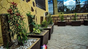 A courtyard with potted plants and a stone pathway. - The Gem Hotel Naivasha (Naivasha)