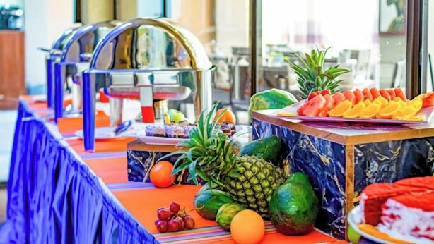 A buffet table with a variety of fruits and a water dispenser. - The Gem Hotel Naivasha (Naivasha)