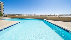 Une piscine offrant une vue dégagée sur la plage, avec une clôture en arrière-plan.