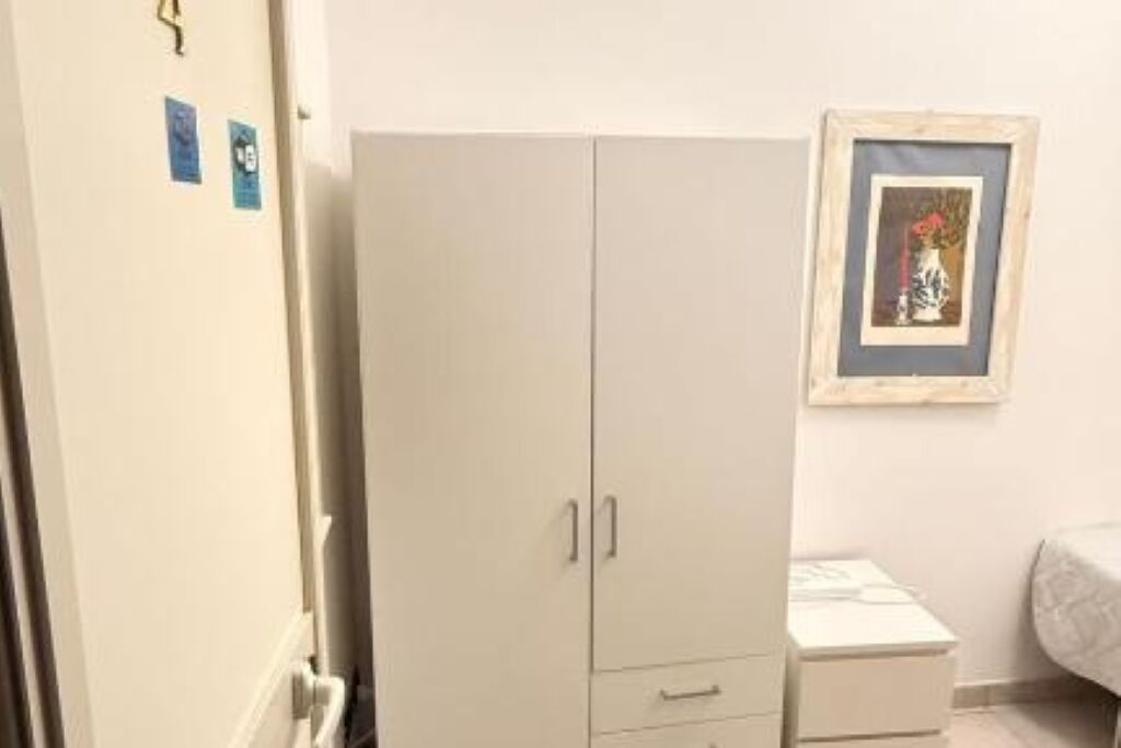 Ein Schlafzimmer mit einem Bett, einem Kleiderschrank und einem Nachttisch.