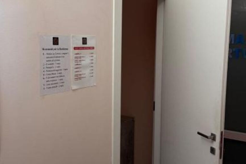 A door with a sign listing room amenities and a partially visible room number.