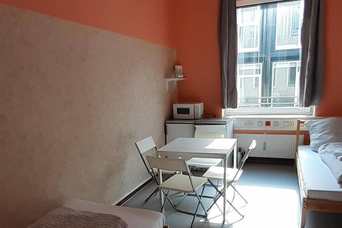 A compact room with a bed, a desk, and a chair.